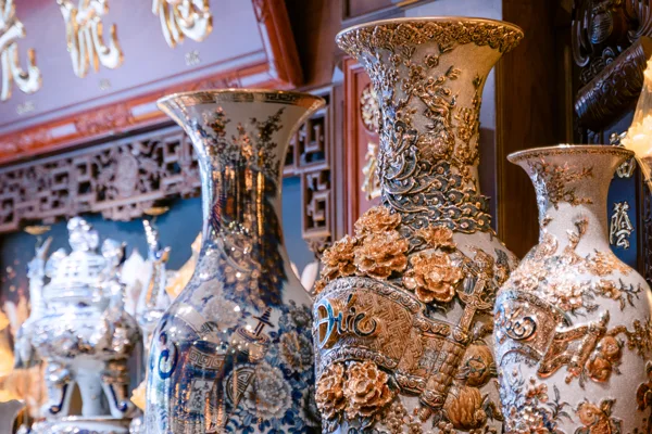 Ba bình cao đứng gần nhau: bình trái xanh trắng vẽ hoa, bình giữa nền sáng có chim đuôi dài và hoa nổi vàng, bình phải nhỏ hơn với hoa văn nổi.