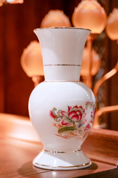 Bình trắng cổ cao miệng loe, thân tròn có hoa sen hồng lá xanh, nhiều đường viền vàng mảnh ở miệng, cổ và chân.