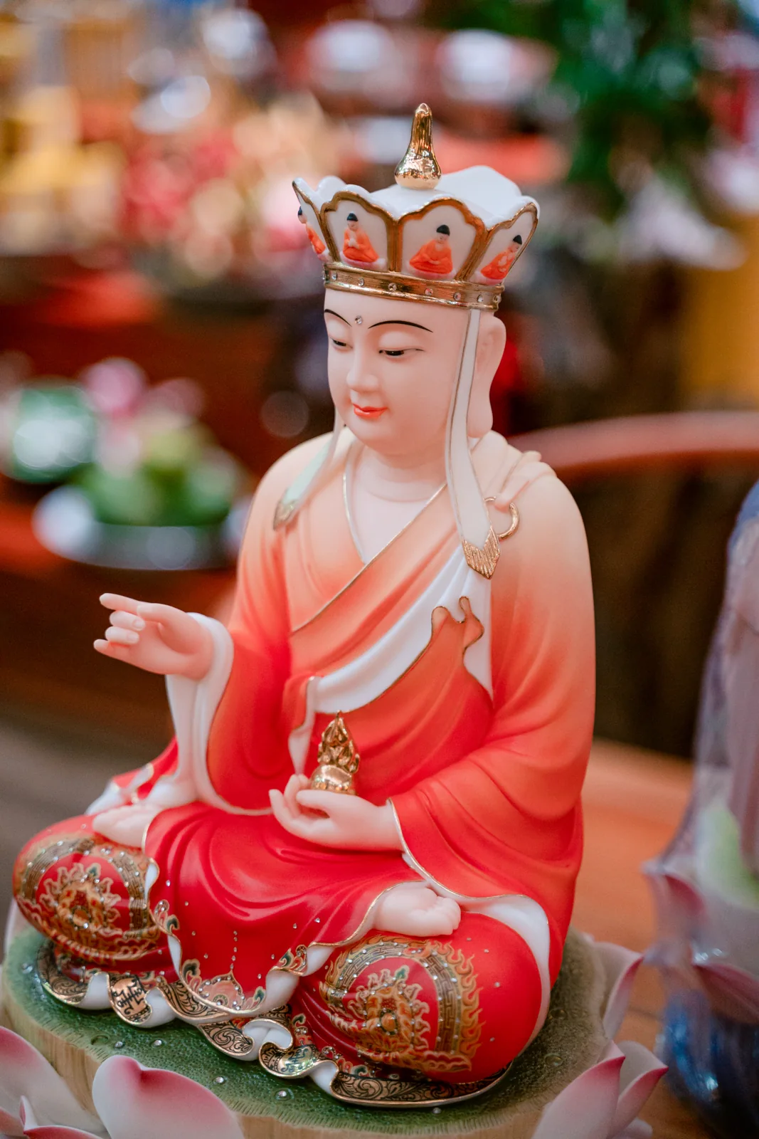 Tượng ngồi trên tòa sen với sắc đỏ và chi tiết trang trí.