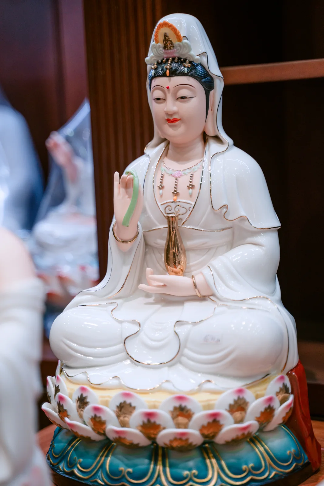 Tượng Quan Âm ngồi trên tòa sen, tông trắng và viền nhiều màu.