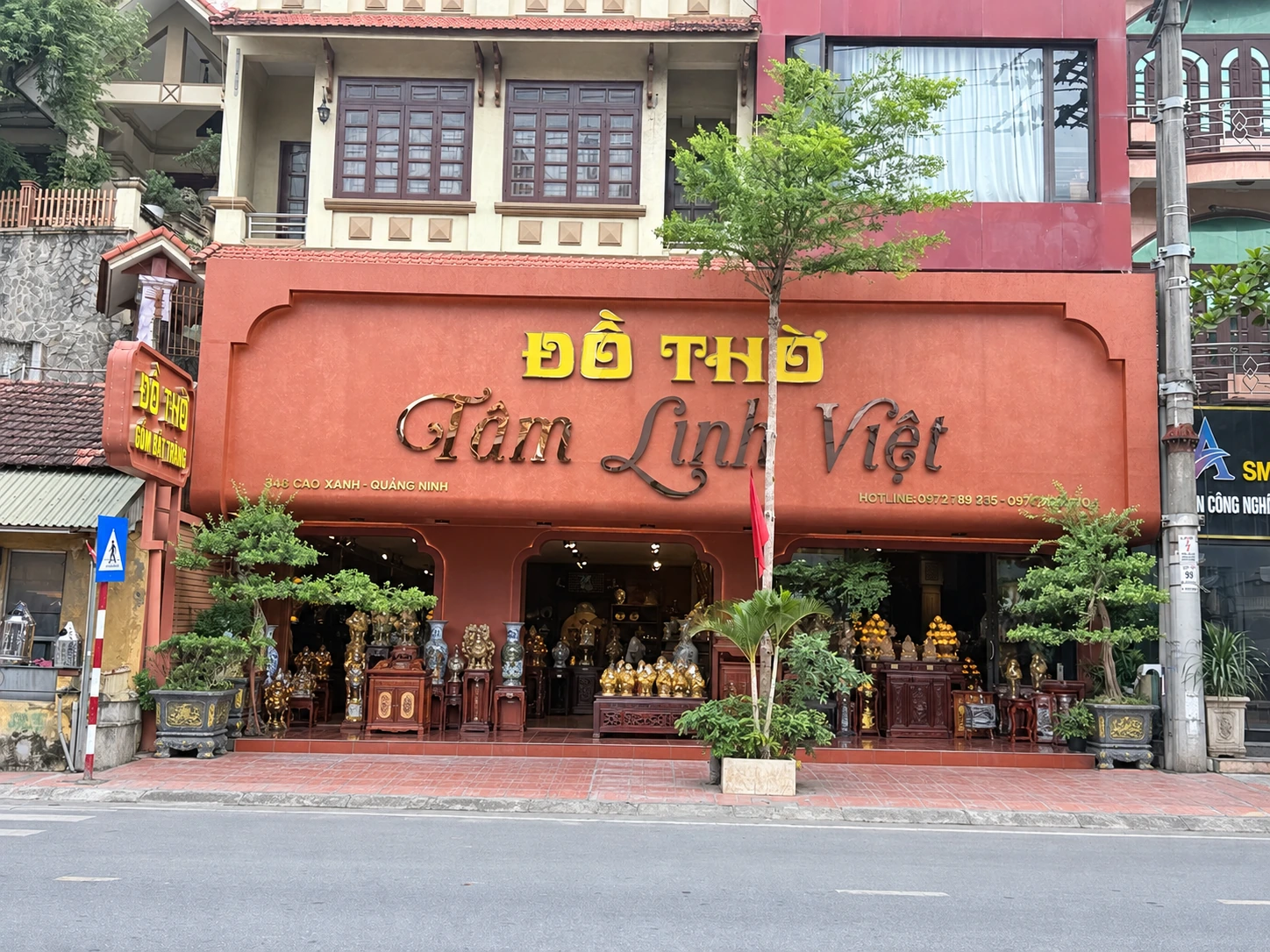 Mặt tiền với biển Đồ Thờ Tâm Linh Việt, nền đỏ đất, chữ vàng và đồng sẫm; phần phía trước đã làm gọn cảnh
