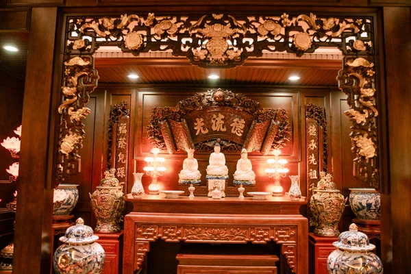 Khung trang trí tông nâu bao quanh bàn cùng ba tượng màu sáng và các điểm đèn hai bên.